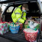 Jon Wilson, who hand-crafts toy blocks, unloads wrapped baskets for donation to the Sky Valley Food Bank on Wednesday in Monroe. (Olivia Vanni / The Herald)