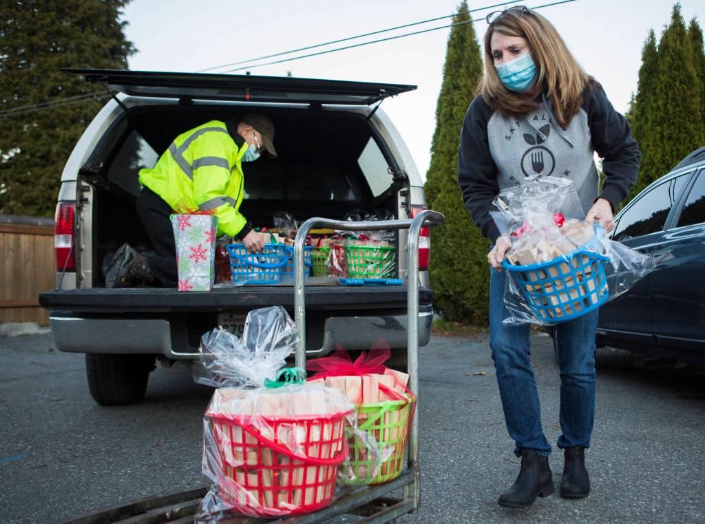 Sky Valley Food Bank Executive Director Cindy Chessie helps unload Jon Wilsons toy block donations on Wednesday in Monroe. (Olivia Vanni / The Herald)