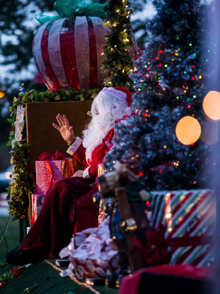 Santa Claus waves goodbye from his festive float during the socially distanced meet-up hosted by Maryfest on Thursday in Marysville. (Olivia Vanni / The Herald)