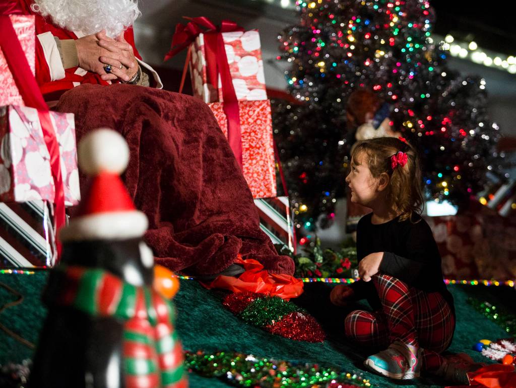 Emily Hatley, 5, smiles at Santa Claus during the socially distanced meet-up hosted by Maryfest on Thursday in Marysville. (Olivia Vanni / The Herald)