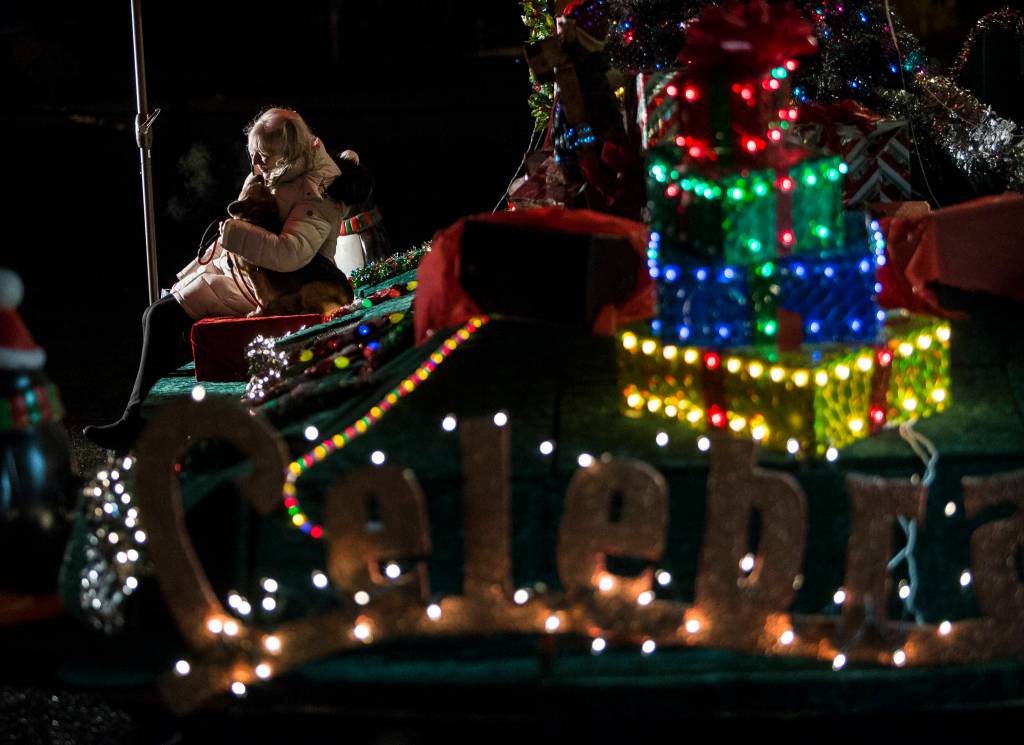 People take photographs with Santa Claus, who is set up on a festival float, Thursday in Marysville. (Olivia Vanni / The Herald)