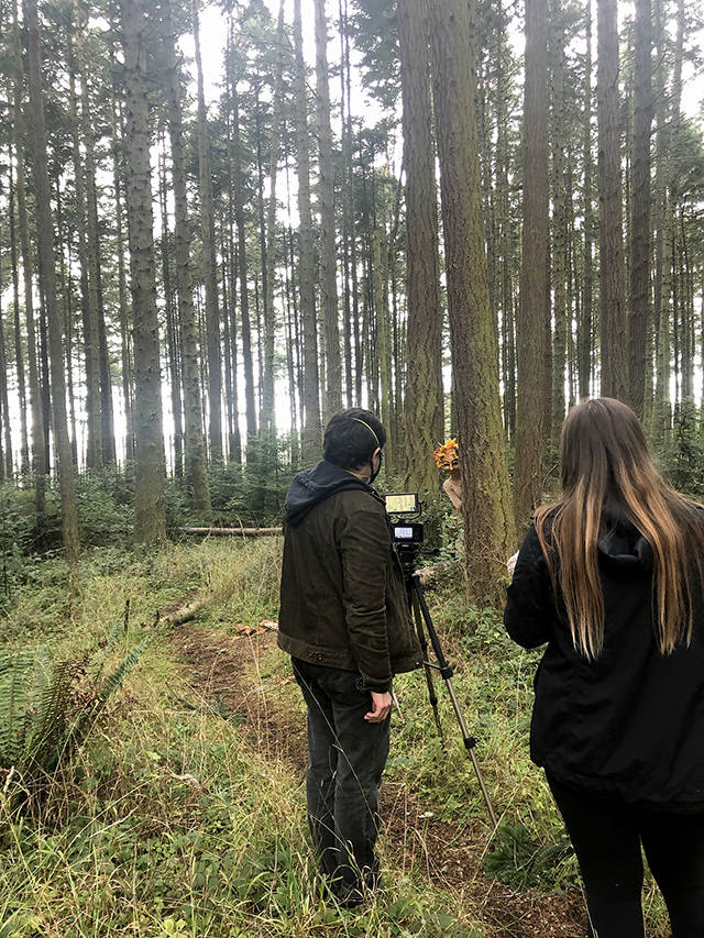 Forest pixie Amelia Rochholz dances through the Whidbey woods as videographer Nick Dubesa, and his assistant Elliauna McLean film the scene. (Grace Swanson)