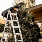 Lauren Sebers (on ladder) and Crystal Stewart decorate a tree for the Trees of Christmas drive-thru event scheduled for Dec. 3-6 in the Everett Bible Baptist Churchs parking lot. (Maria Lara)