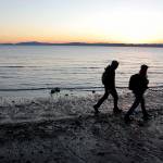 In this 2013 photo, two people walk the beach at Discovery Park in Seattle. (AP Photo/Manuel Valdes, file)