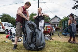 Jack Travis gets help packing up his tent at the Rucker Avenue homeless camp on Thursday, July 9, 2020 in Everett, Wa. (Olivia Vanni / The Herald)