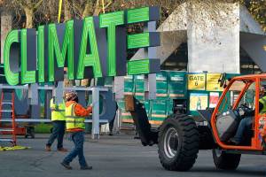 Workers assemble signs for the top of Climate Pledge Arena (shown in the background), the future home of the Seattle Kraken NHL hockey team and the Seattle Storm WNBA team, Thursday, Dec. 3, 2020, in Seattle. The signs are scheduled to be installed on the roof of the facility by a helicopter on Saturday. (AP Photo/Ted S. Warren)