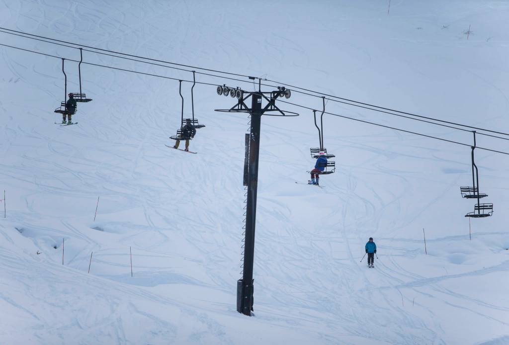 People ride one person to a chair on opening day at Stevens Pass last Friday. (Olivia Vanni / The Herald)