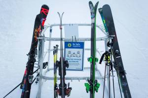 Signs reminding people to stay six feet apart hang on a ski and snowboard rack on opening day at Steven's Pass on Friday, Dec. 4, 2020 in Skykomish, Wa. (Olivia Vanni / The Herald)