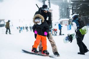 Jarrell Banks helps his daughter Londyn, 4, learn how to stop on her snowboard during her first time snowboarding on opening day at Steven's Pass on Friday, Dec. 4, 2020. (Olivia Vanni / The Herald)