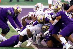 Stanford running back Nathaniel Peat, center, pushes into the end zone on a 3-yard touchdown run against Washington in the first half of an NCAA college football game Saturday, Dec. 5, 2020, in Seattle. (AP Photo/Elaine Thompson)