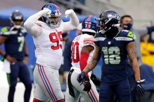 New York Giants defensive end Leonard Williams, left, reacts next to Seattle Seahawks wide receiver Freddie Swain (18) after a play during the second half of the Seahawks 17-12 loss Sunday at Lumen Field. (AP Photo/Larry Maurer)