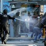FILE - In this July 25, 2020, file photo, police pepper spray protesters, near Seattle Central College in Seattle, during a march and protest in support of Black Lives Matter. Washington state lawmakers and activists are setting an ambitious agenda for police reform in the upcoming legislative session. They say they hope to make it easier to decertify officers for misconduct, to bar the use of police dogs to make arrests, and to create an independent statewide agency to investigate police killings. (AP Photo/Ted S. Warren, File)