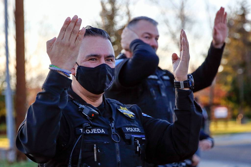 Police officers recognize participants in a memorial parade for missing Tulalip officer Charlie Cortez Saturday afternoon on the Tulalip Reservation. (Kevin Clark / The Herald)
