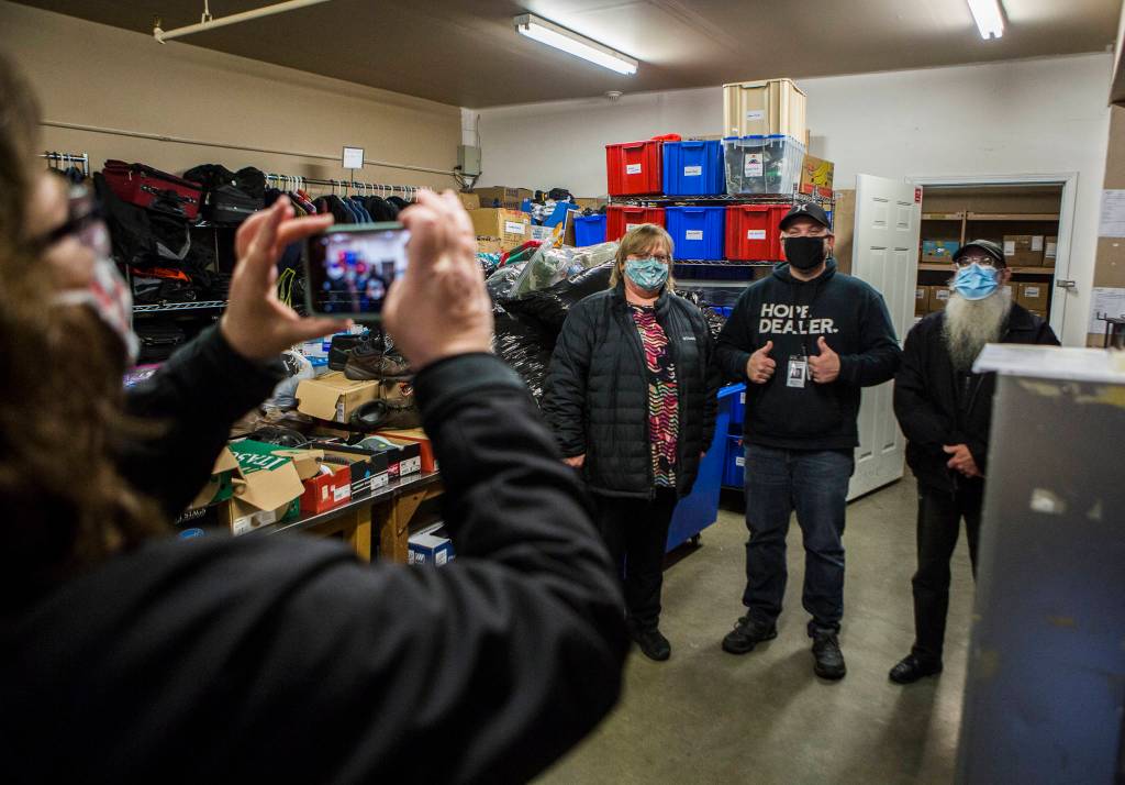 Tonja Jones takes a photo with Everett Gospel Mission coordinator Jeremiah Swartz on Dec. 10 in Everett. (Olivia Vanni / The Herald)