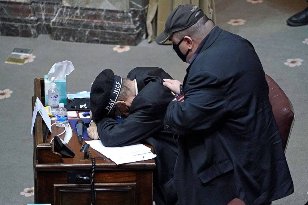 Jack Arends (left) is comforted by fellow elector Julian Wheeler on Monday in Olympia after Arends became emotional while talking about his failing health and the importance of being able to cast his vote. (AP Photo/Ted S. Warren)