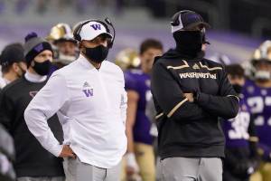 Washington coach Jimmy Lake, left, stands on the sideline during the first half of the team's NCAA college football game against Utah, Saturday, Nov. 28, 2020, in Seattle. (AP Photo/Ted S. Warren)