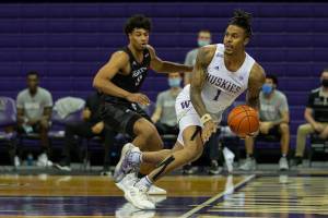Washington's Nate Roberts (right) saves the ball from going out of bounds during a game against Seattle University on December 9, 2020, at Alaska Airlines Arena in Seattle. (Scott Eklund/UW Athletics)