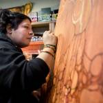Luisana Lu Hernandez works on a large canvas piece titled Madre Mia in her Everett studio. (Olivia Vanni / The Herald)