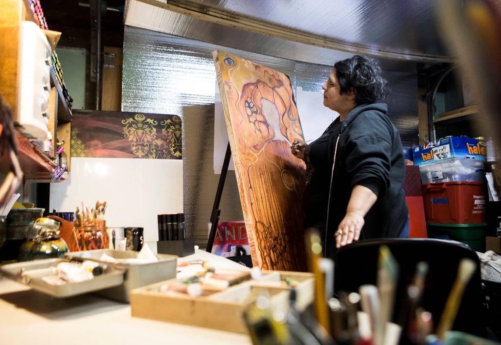 Lu Hernandez works in her studio, in the garage of her Everett home. (Olivia Vanni / The Herald)