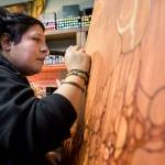 Lu Hernandez works on a large canvas piece, Madre Mia, in her studio on Friday, Dec. 11, 2020 in Everett, Wa. (Olivia Vanni / The Herald)