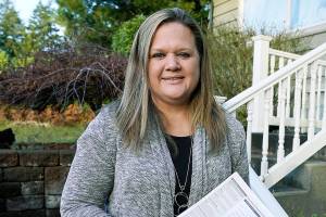 Rep. Tarra Simmons, D-Bremerton, holds blank voter registration forms as she poses for a photo Wednesday, Dec. 9, 2020, at her home in Bremerton, Wash. Simmons, believed to be the first formerly incarcerated person to win election to the Statehouse, is now working to help restore voting rights to people in Washington state who are out on parole or probation after serving prison time. (AP Photo/Ted S. Warren)