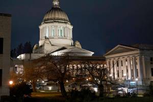 The Legislative Building, left, stands at night after Washington Gov. Jay Inslee and his wife, Trudi, gave a statewide televised address on COVID-19, which health officials have warned is accelerating rapidly throughout the state, Thursday, Nov. 12, 2020, at the Capitol in Olympia, Wash. (AP Photo/Ted S. Warren)