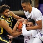 Oregons LJ Figueroa (left) struggles for control of the ball with Washingtons Quade Green (bottom right) and Hameir Wright during the first half of a game Dec. 12, 2020, in Seattle. (AP Photo/Elaine Thompson)