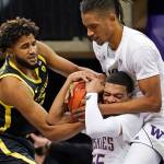 Oregon's LJ Figueroa, left, struggles for control of the ball with Washington's Quade Green, bottom right, and Hameir Wright during the first half of an NCAA college basketball game Saturday, Dec. 12, 2020, in Seattle. (AP Photo/Elaine Thompson)