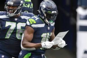 Seattle Seahawks wide receiver DK Metcalf reads a birthday note handed him by his teammates after he scored a touchdown against the New York Jets during the first half Sunday at Lumen Field. (AP Photo/Lindsey Wasson)