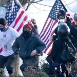 Supporters of President Donald Trump and antifa supporters clashed with Washington state police on the state Capitol Campus in Olympia, Wash., Saturday, Dec. 12, 2020. Police in Olympia declared a riot early Saturday afternoon and arrested at least one person as groups with different points of view held simultaneous protests. (The Olympian via AP)