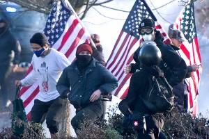 Supporters of President Donald Trump and antifa supporters clashed with Washington state police on the state Capitol Campus in Olympia, Wash., Saturday, Dec. 12, 2020. Police in Olympia declared a riot early Saturday afternoon and arrested at least one person as groups with different points of view held simultaneous protests. (The Olympian via AP)