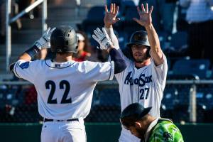 The Everett AquaSoxs Connor Hoover high-fives Carter Bins after scoring during a game against the Eugene Emeralds in 2019 at Funko Field. (Olivia Vanni / The Herald)