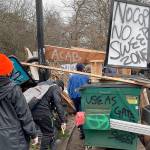 The homeless camp is completely encircled with debris and fencing blocking the City of Seattle's sweep of the camp Cal Anderson Park, Wednesday, Dec. 16, 2020, in Seattle. This is the only entrance to the area within the park. (Steve Ringman/The Seattle Times via AP)