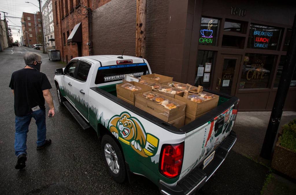 Jim Staniford loads up his truck bed with meals to be delivered Thursday to the Everett Gospel Mission in Everett. (Olivia Vanni / The Herald)