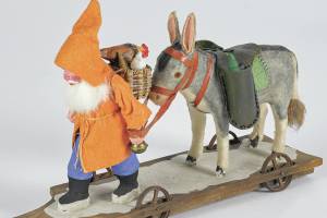 This hardworking Santa in an orange and blue outfit is carrying toys with a donkey not a reindeer. The 8-inch toy was made in Germany. (Cowles Syndicate Inc.)