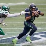 Seahawks quarterback Russell Wilson (right) scrambles against the Jets during the first half of a game Dec. 13, 2020, in Seattle. (AP Photo/Ted S. Warren)