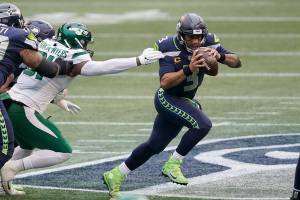 Seattle Seahawks quarterback Russell Wilson, right, scrambles against the New York Jets during the first half of an NFL football game, Sunday, Dec. 13, 2020, in Seattle. (AP Photo/Ted S. Warren)