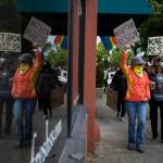 A group of protesters holding signs calling for Snohomish Mayor John Kartaks resignation walk down First Street on June 5 in Snohomish. (Olivia Vanni / The Herald)