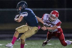 Arlington’s Cade Younger is tackled by Marysville-Pilchuck’s Kyle Nyblod during the game on Oct. 25, 2019 in Arlington, Wash. (Olivia Vanni / The Herald)