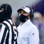 Washington coach Jimmy Lake stands with official Michael Weseloh as he waits for a review of a call during the second half of a game against Stanford on Dec. 5, 2020, in Seattle. (AP Photo/Elaine Thompson)
