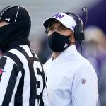 Washington coach Jimmy Lake stands with official Michael Weseloh as he waits for a review of a call during the second half of the team's NCAA college football game against Stanford on Saturday, Dec. 5, 2020, in Seattle. (AP Photo/Elaine Thompson)