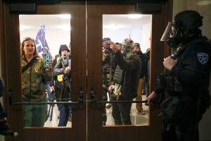 Protesters try to get into the Oregon State Capitol during a special session of the state legislature in Salem, Ore., on Monday, Dec. 21, 2020. State police declared an unlawful assembly at Oregon’s Capitol building as protesters opposed to COVID-19 restrictions attempted to force their way in during the third special legislative session. (Abigail Dollins/Statesman-Journal via AP)
