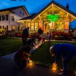 The McCoy Family, along with help from neighbors, light the luminaries lining their walkway along the 1200 block of Rucker on Thursday, Dec. 24, 2020 in Everett, Wa. (Olivia Vanni / The Herald)