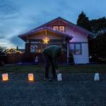 Bob Robison lights the luminaries in front of his home along the 1200 block of Rucker Avenue on Thursday, Dec. 24, 2020 in Everett, Wa. (Olivia Vanni / The Herald)