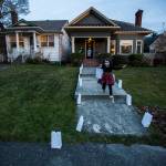 Vivienne Smothers, 6, runs to help set up luminaries along the 1200 block of Rucker Avenue on Thursday, Dec. 24, 2020 in Everett, Wa. (Olivia Vanni / The Herald)
