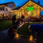 The McCoy Family, along with help from neighbors, light the luminaries lining their walkway along the 1200 block of Rucker on Thursday, Dec. 24, 2020 in Everett, Wa. (Olivia Vanni / The Herald)