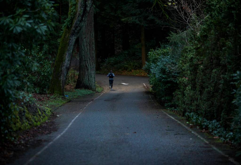 Wes Plate runs down Park Road through Forest Park on Sunday, Dec. 20, 2020 in Everett. (Olivia Vanni / The Herald)