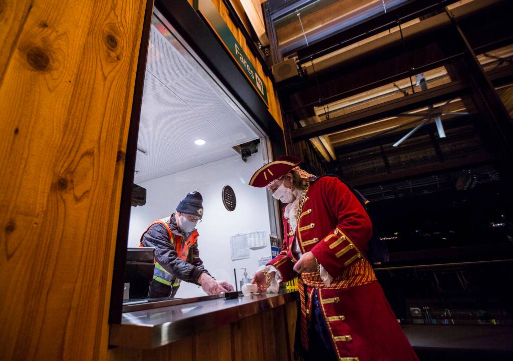 MukFest Pirate George buys a walk-on ticket inside the new Mukilteo ferry terminal on Tuesday. (Olivia Vanni / The Herald)