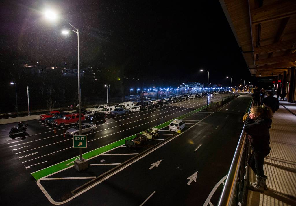 People watch as car lanes begin to fill at the new Mukilteo ferry terminal on Tuesday. (Olivia Vanni / The Herald)