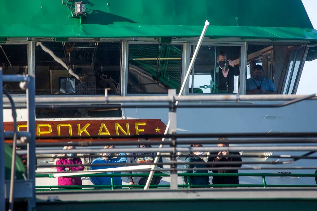 From the bridge of the MV Spokane, a Washington State Ferries crew takes photos of spilled logs blocking the ramp of the Edmonds terminal on Monday. (Andy Bronson / The Herald)